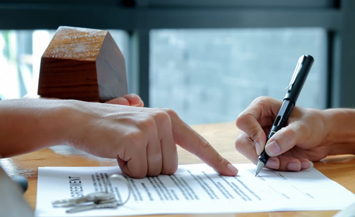 una persona realizando la firma de una escritura de inmuebles