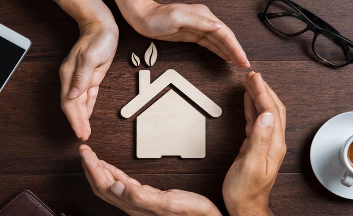 manos y casa simbolizando un hogar más sostenible