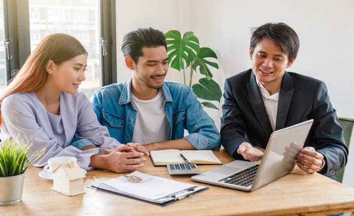 tres personas haciendo la revisión de las cláusulas de un contrato de alquiler