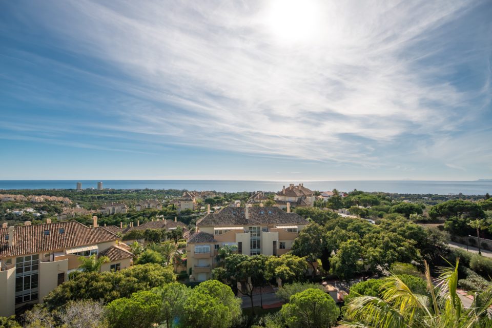 A aerial view of the Elviria Hills apartments complex with sea views in the background